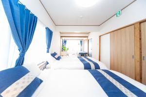 四日市Yokkaichi Motomachi Hotel的带窗户的客房内的两张床