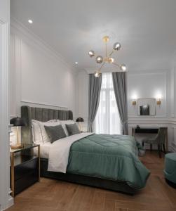 雅典Praxitelous Luxury Suites的一间卧室配有一张大床和一个吊灯。