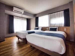 东京ulu Tokyo的带窗户的酒店客房内的两张床