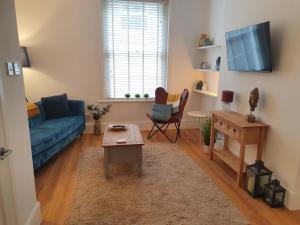 伊普斯威奇One Bedroom Flat Central Ipswich的客厅配有蓝色的沙发和桌子