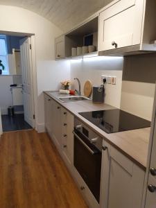 伊普斯威奇One Bedroom Flat Central Ipswich的厨房配有白色橱柜和黑炉灶烤箱。