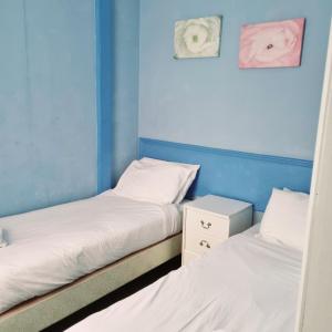 布莱克浦新奥斯特利酒店的蓝色墙壁客房中的两张单人床