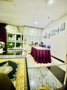 PakaPaka Tamim Seaview Hotel的一间设有一张桌子的房间,配有紫色的桌布