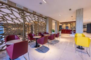 玛塔弗瑞德Avar Hotel的大堂内的餐厅,配有五颜六色的桌椅