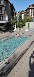 班斯科Bansko Luxury apartment in St Ivan Rilski Spa 4 Bansko Private SPA & Minreal Hot water pools的三人在游泳池游泳