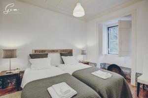 里斯本Casa Dos Azulejos - Lapa的卧室设有两张床,拥有白色的墙壁和窗户。