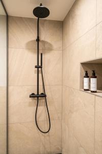 弗莱堡Black F Tower - Serviced Apartments的浴室内配有淋浴和头顶淋浴