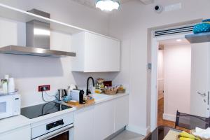罗马Emma 12的白色的厨房配有白色橱柜和水槽