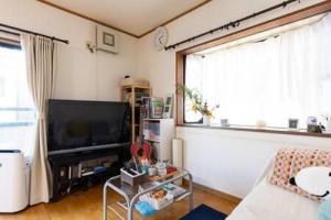 川崎Noriko's Home - Vacation STAY 8643的客厅设有大窗户和电视。