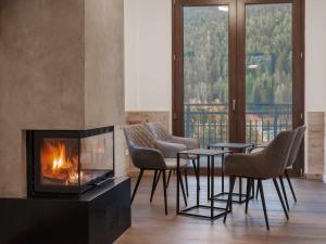 蓬泰迪莱尼奥Hotel Garnì Alta Valle的客厅设有壁炉、椅子和桌子