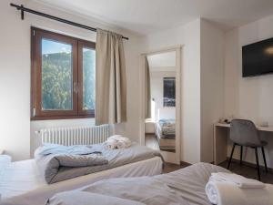 蓬泰迪莱尼奥Hotel Garnì Alta Valle的一间卧室配有两张床,上面有泰迪熊