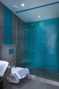 利迈纳里亚El Mare Seaside Retreats - Bespoke Luxury Getaways的蓝色瓷砖浴室配有淋浴和卫生间。