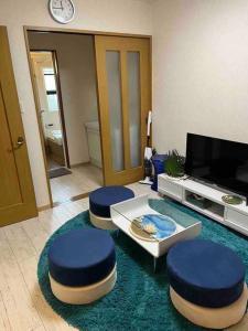 高松民宿　setouchi的客厅配有2张蓝色凳子和电视