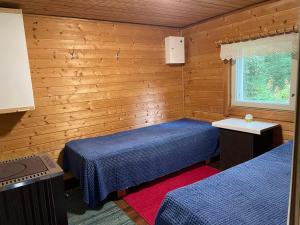 VuoriniemiVilla Mushroom的配有木墙和窗户的客房内的两张床