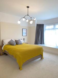 红山1 Ashford Road Guesthouse的一间卧室配有一张带黄色毯子的大床