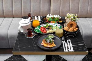 伊斯坦布尔Wish More Hotel Şişli的餐桌上放有食物盘子的桌子