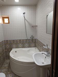 希瓦Khiva Ibrohim Guest House的带浴缸和盥洗盆的浴室