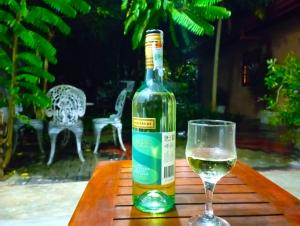 本托塔Olee Villa的一瓶葡萄酒和一张桌子上的一杯