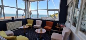 尚克林海峡美景酒店的一间设有桌椅和窗户的餐厅,享有海景