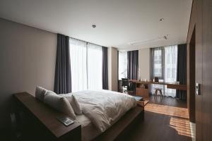 釜山Good Ol' Days Hotel的卧室配有一张床、一张书桌和窗户。