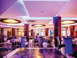 达累斯萨拉姆Peninsula Hotel Dar Es Salaam的用餐室配有桌椅和吊灯。
