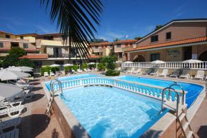 托尔托雷托埃尔博尔戈酒店的一个带椅子和遮阳伞的度假村游泳池