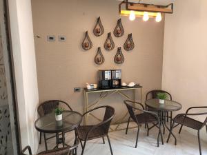 危地马拉L'Aurora Inn的配有桌椅和墙上咖啡机的房间