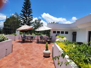 危地马拉L'Aurora Inn的房屋内带桌子和遮阳伞的庭院