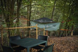 马里博尔Tents resort Posestvo SONČNI RAJ的树林里的帐篷,配有桌椅