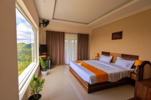 钦纳卡纳The Windy Mist Resort Munnar的一间卧室设有一张床和一个大窗户