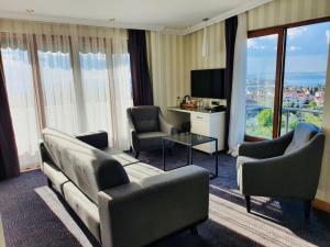 科贾埃利DOUBLE ROYAL HOTEL的酒店客房设有沙发、椅子和电视。