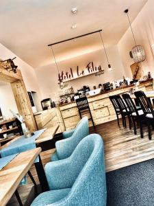 希勒Hotel Le Filou的一间设有蓝色桌椅和柜台的餐厅