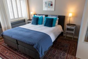 马斯特里赫特Guesthouse Thoez的一间卧室配有一张带蓝色枕头的大床