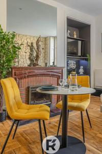格勒诺布尔R'Apparts Studio Chic des Quais的客厅配有桌子和2把黄色椅子