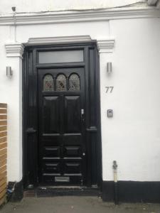 CranfordSelf-contained Studio near Heathrow - 77VFR1的建筑物一侧的黑色门