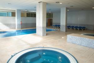 萨洛黄金海岸索尔酒店的一座带游泳池的大楼内的大型游泳池