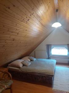 特尔乔夫PENZIÓN U JANOSIKA的木天花板的客房内的一张床位
