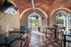 蒙蒂恰诺La Locanda di Petriolo的餐厅设有桌椅和窗户。