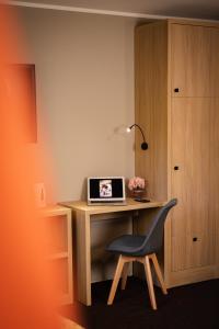 比得哥什百思特酒店的一张桌子,一张笔记本电脑和一把椅子放在房间里