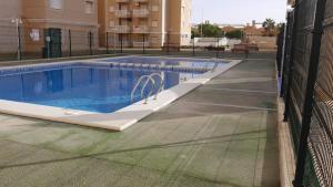 卡塔赫纳Playa Paraiso - Penthouse Apartment - Secure Free Parking and WiFi的一座游泳池,旁边是一座建筑,设有围栏