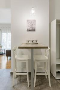 塞萨洛尼基NAVA Apartment in the center of Thessaloniki的白色餐桌和两把白色椅子