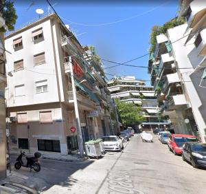 雅典Luxury apartment in Sepolia的一条街道,汽车停在大楼的一侧