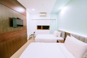 瓜埠The Concept Hotel Langkawi的酒店客房设有两张床和一台平面电视。