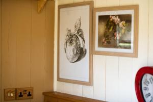 Pen y ClawddHarrys Hideout - Shepherd's Huts at Harrys Cottages的墙上有两张带时钟的帧图片
