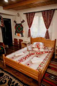 BrebCasa Pintea de Sub Coastă的一间卧室配有一张红色玫瑰花顶的大床