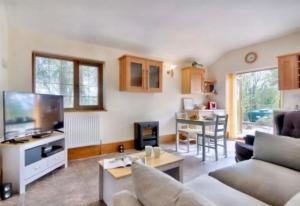 LlanhamlachMountain View Cottage, Hot Tub , Stunning Views的带沙发、电视和桌子的客厅