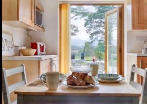 LlanhamlachMountain View Cottage, Hot Tub , Stunning Views的厨房里配有一张桌子,上面有盘子的食物