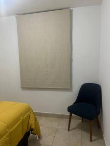 伊察Departamento en Ica的一间卧室配有一张床和一张蓝色椅子