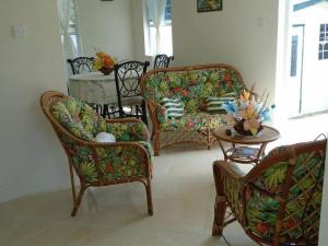 圣詹姆斯Simply Beautiful Two Storey home/apt awaits you的客厅配有两把椅子、一张沙发和一张桌子