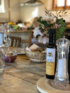 特拉西梅诺湖畔托罗La Fattoria del Rio di Sopra - Agriturismo Baldeschi的木桌旁的一瓶葡萄酒